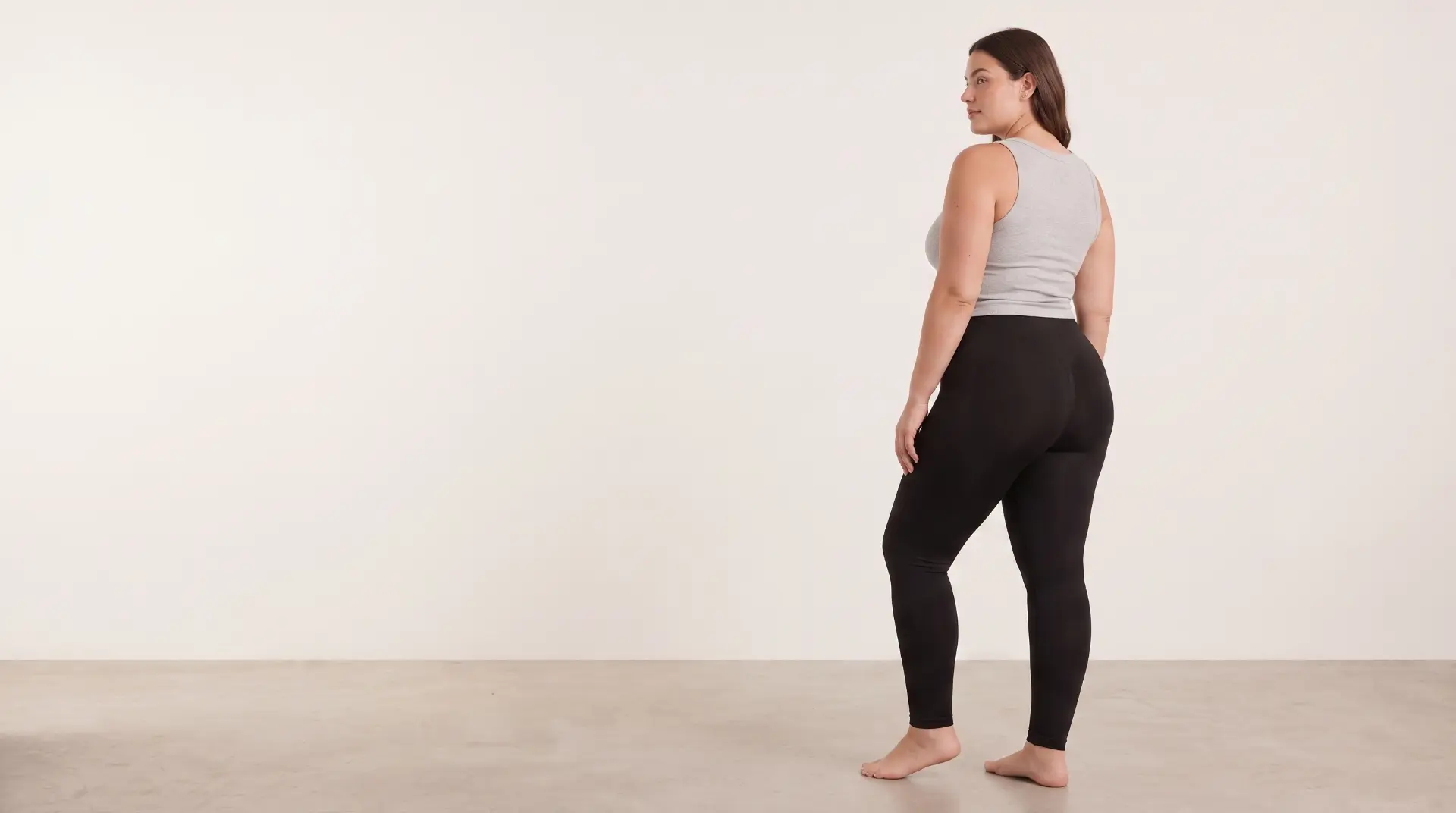 Model draagt een zwarte Lissea-legging, van opzij gefotografeerd